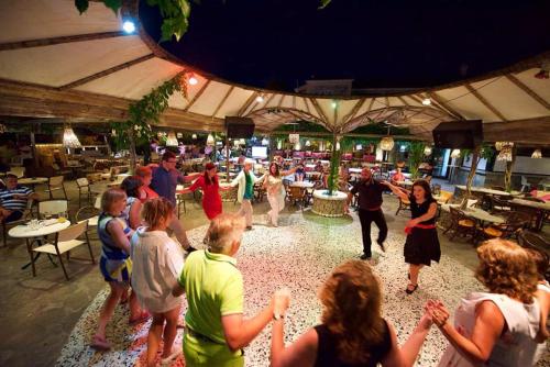 a group of people dancing in a room at Molfetta Beach Hotel  in Gouvia