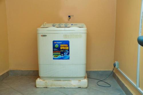 a washing machine sitting in a corner of a room at Lovely 2-Bed Apartment in Kampala in Kampala