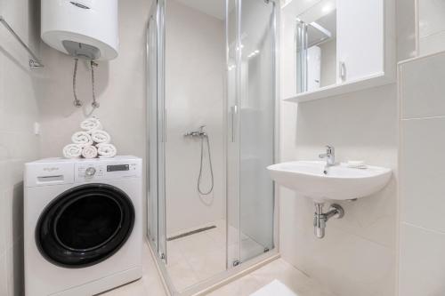 a bathroom with a washing machine and a sink at Central One-Bedroom Apartment in Budva