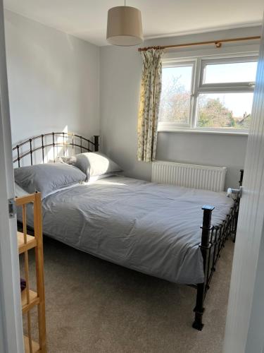 2 łóżka w sypialni z oknem w obiekcie Bright and airy 3 bedroom home near southwold w mieście Wangford