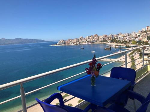 a table on a balcony with a view of the water at Genci Seaview Apartaments@AlbaResidence in Sarandë