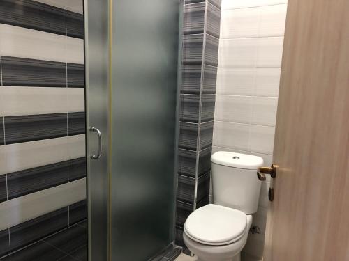 a bathroom with a toilet and a door at Genci Seaview Apartaments@AlbaResidence in Sarandë