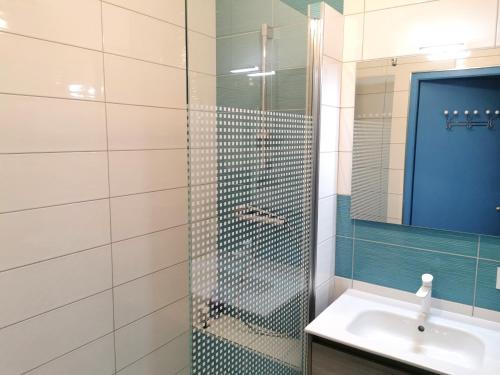 ein Badezimmer mit Dusche, Waschbecken und Spiegel in der Unterkunft Le Lagon Bleu in Les Sables-dʼOlonne