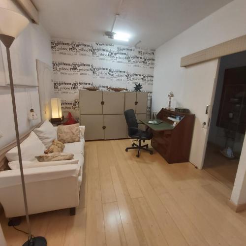 a living room with a white couch and a desk at Habitacion en apartamento Vegueta in Las Palmas de Gran Canaria