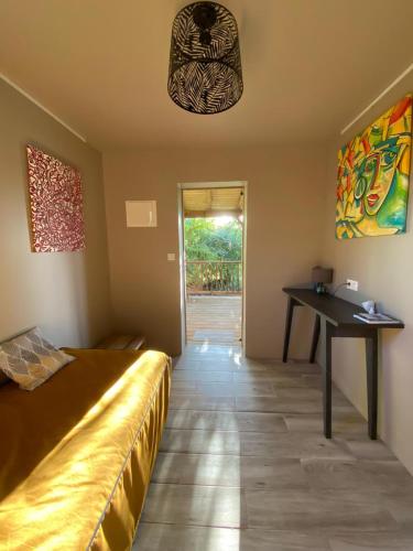 a bedroom with a bed and a desk and a table at CAP 8 in Le Marin
