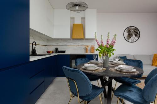 kuchnia ze stołem i niebieskimi krzesłami w obiekcie SOHO 18 Apartment by Renters Prestige w Warszawie