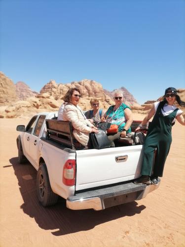 a group of people in the back of a truck in the desert at Rum Aranda camp & Jeep Tour in Wadi Rum