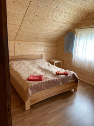 a bedroom with a bed in a wooden cabin at Медові Карпати in Oryavchyk