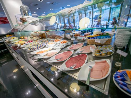 a buffet line with meat and other foods on plates at Aquis Grana City Hotel in Aachen