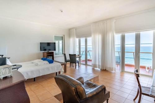 a living room with a bed and a table and chairs at Boa Vista Hotel & Spa - Adults Only in Albufeira