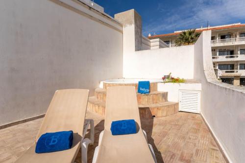 a balcony with two chairs and a table and some stairs at Boa Vista Hotel & Spa - Adults Only in Albufeira