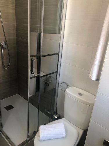 a bathroom with a toilet and a glass shower at Apartamento Maracena C/ Ramón y Cajal in Maracena