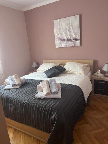 1 dormitorio con 1 cama grande y 2 toallas. en Sun & More Apartment, en Crikvenica