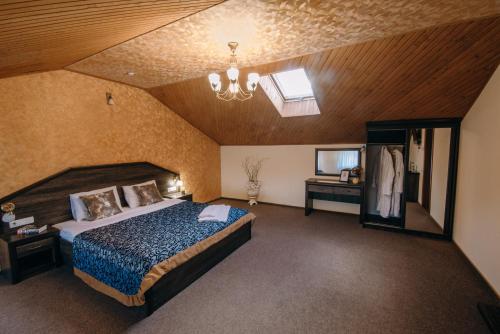 Un dormitorio con una cama grande y una lámpara de araña. en Готель Скіфія en Leópolis