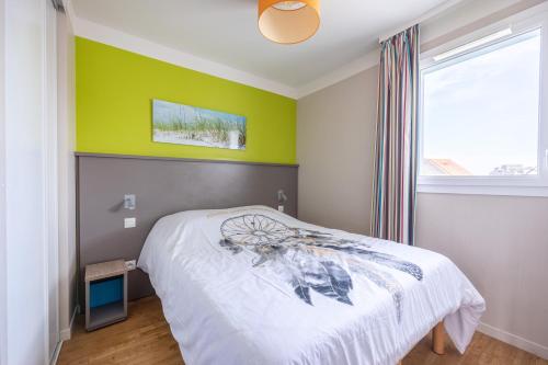 1 dormitorio con cama y pared verde en Le Bécasseau Sanderling, en Courseulles-sur-Mer