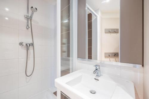 une salle de bain blanche avec une douche et un lavabo dans l'établissement Le Bécasseau Sanderling, à Courseulles-sur-Mer