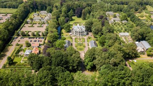 een luchtzicht op een groot herenhuis met bomen bij Kasteel De Vanenburg in Putten