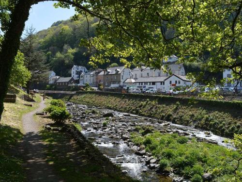 a river in front of a town with houses at East Lyn House in Lynmouth
