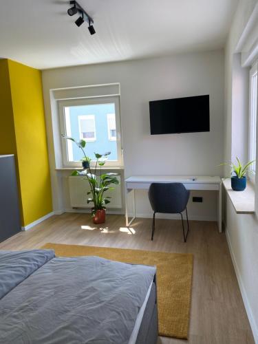 a bedroom with a bed and a desk and a tv at Himmlische Weite 3 in Schweinfurt