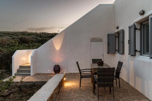 a patio with a table and chairs next to a building at Kalliston Naxos in Akrotiri