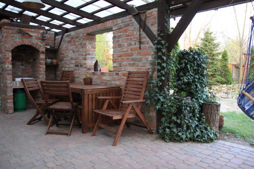 un patio con mesa y sillas bajo un edificio de ladrillo en Wolna Chwila, en Maków