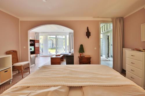 ニーンドルフにあるFerienbungalow Erlenweg 20 Erlenweg 20 Appartement 2 Niendorf Ostseeの大きなベッドと机のある寝室