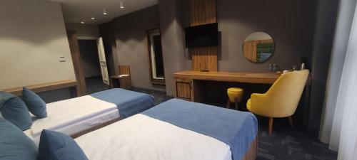 a hotel room with two beds and a desk at ERTA SOYAK THERMAL OTEL in Çekirge