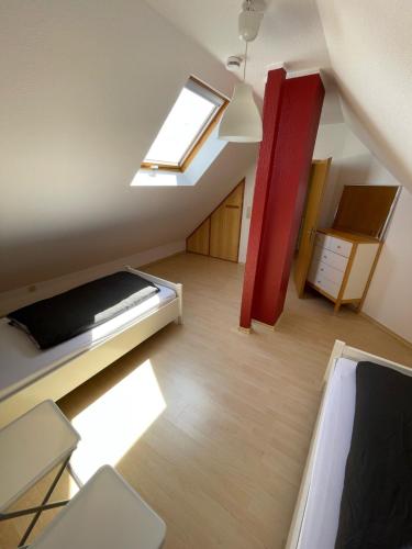 een zolderkamer met een bed en een raam bij Ferienwohnung KÖÖK I - echter Inselblick in Neuharlingersiel