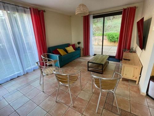 un salon avec un canapé bleu et des chaises dans l'établissement Villa Salagou - Vue sur le lac - Liausson 34800 - 6-8 pers - 100m2, à Liausson