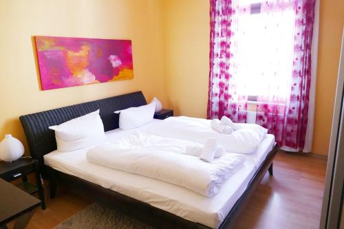 Schlafzimmer mit einem Bett mit weißer Bettwäsche und einem Fenster in der Unterkunft Villa Medici App_ 02 in Ahlbeck