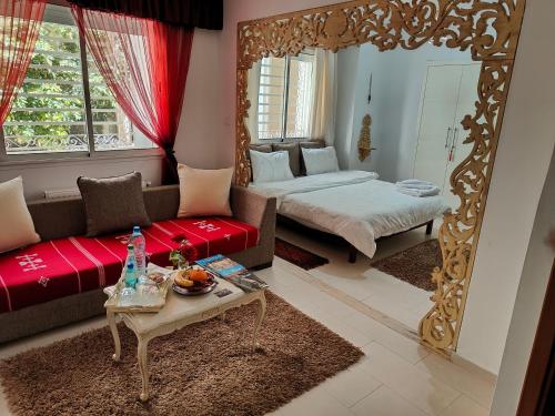 a living room with a red couch and a mirror at Dar La Leila in Tunis