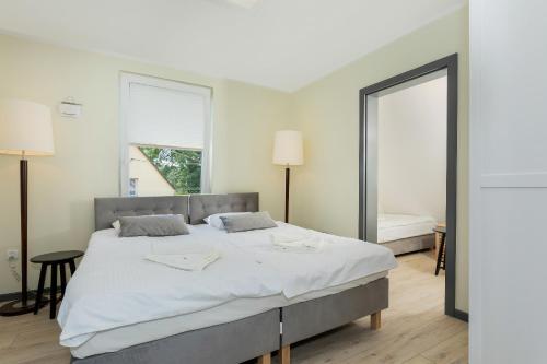 a bedroom with a large bed and a large mirror at Dom Wakacyjny Viking in Kołczewo