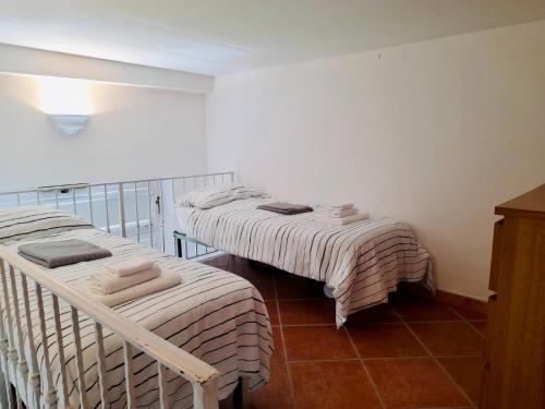 two twin beds in a room with a tiled floor at Villa Alessandro - Anacapri in Anacapri