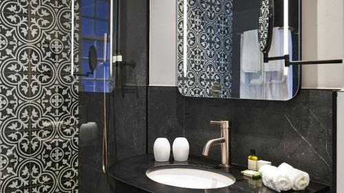 a bathroom with a sink and a mirror at The Winchester Hotel by NEWMARK in Cape Town