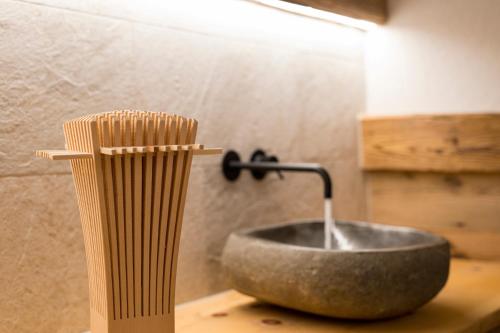 a bathroom with a stone sink on a table at Hotel Maibad in Vipiteno