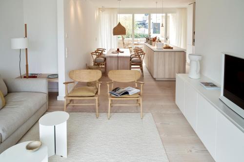 uma sala de estar com um sofá, uma mesa e cadeiras em Inselhouse em Norderney