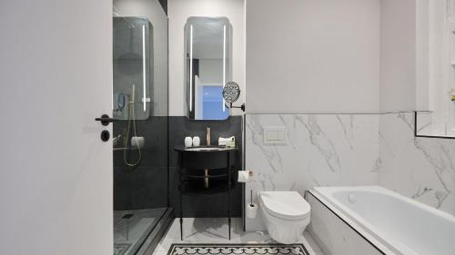 a bathroom with a sink and a toilet and a tub at The Winchester Hotel by NEWMARK in Cape Town