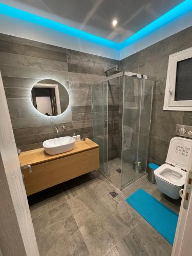 ein Bad mit einem Waschbecken, einer Dusche und einem WC in der Unterkunft Luxury 3 bedroom apartment in Kiato center in Kiato