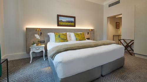 a hotel room with a large bed and a table at The Winchester Hotel by NEWMARK in Cape Town