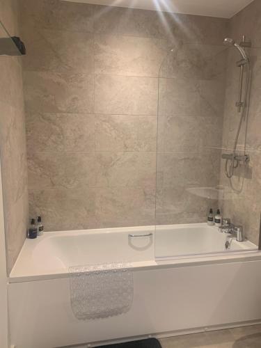 a bathroom with a bath tub with a shower at The Retreat in Weston-super-Mare