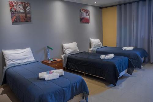 a room with two beds with towels on them at Hotel Posada Las Lengas in Veintiocho de Noviembre