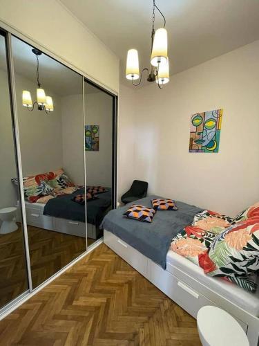 a bedroom with two beds and a mirror at Willa 1936 , Parking in Toruń