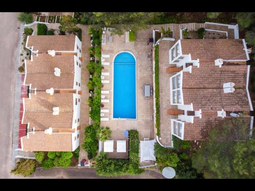 an overhead view of a house with a blue pool at The Desmais in Cala Galdana