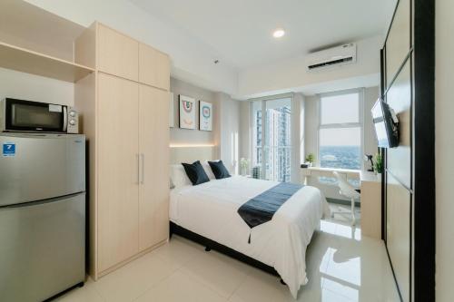 una camera con letto, frigorifero e TV di Kingston Apartment - Anderson Studio A25 a Lontar