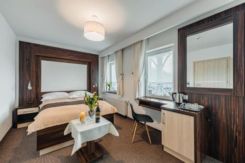 a hotel room with a bed and a desk and a table at Willa Lala in Szczawnica