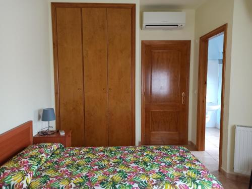 a bedroom with a bed and a wooden closet at Pagés in Sant Climent Sescebes