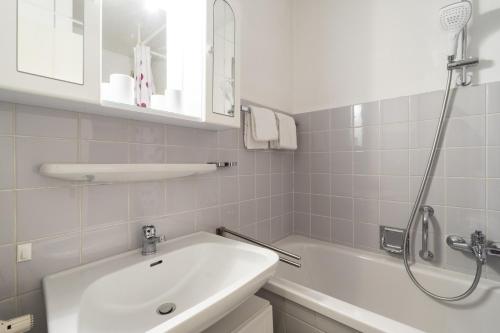 a white bathroom with a sink and a shower at Ferienwohnung Hillgruber in Oberstdorf