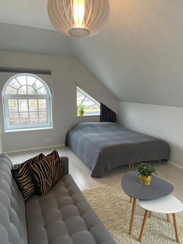 a bedroom with a bed and a couch and a table at Captain's House - Kaptenimaja - Apartments in Kärdla