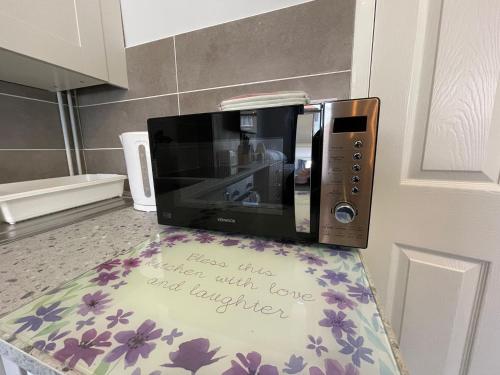 a microwave on a counter with a sign on it at Large Ground Floor Studio Holiday Apartment Skegness - Flat 12 in Skegness