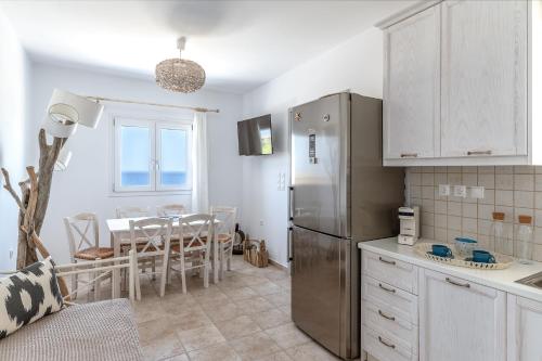 a kitchen with a table and a stainless steel refrigerator at Kalliston Naxos in Akrotiri